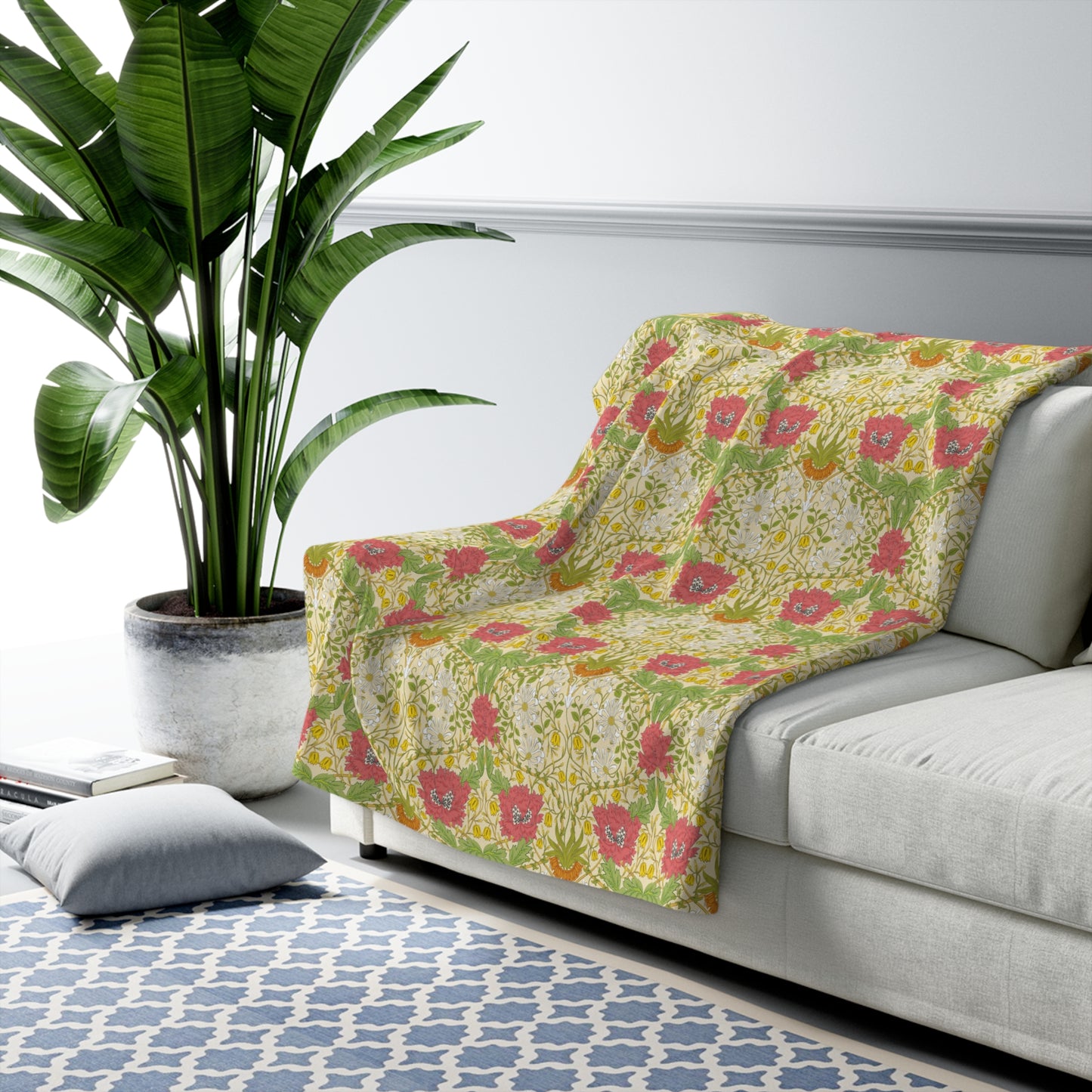 A Sherpa fleece blanket with a floral pattern in pink and yellow hues on a green background, displayed flat.