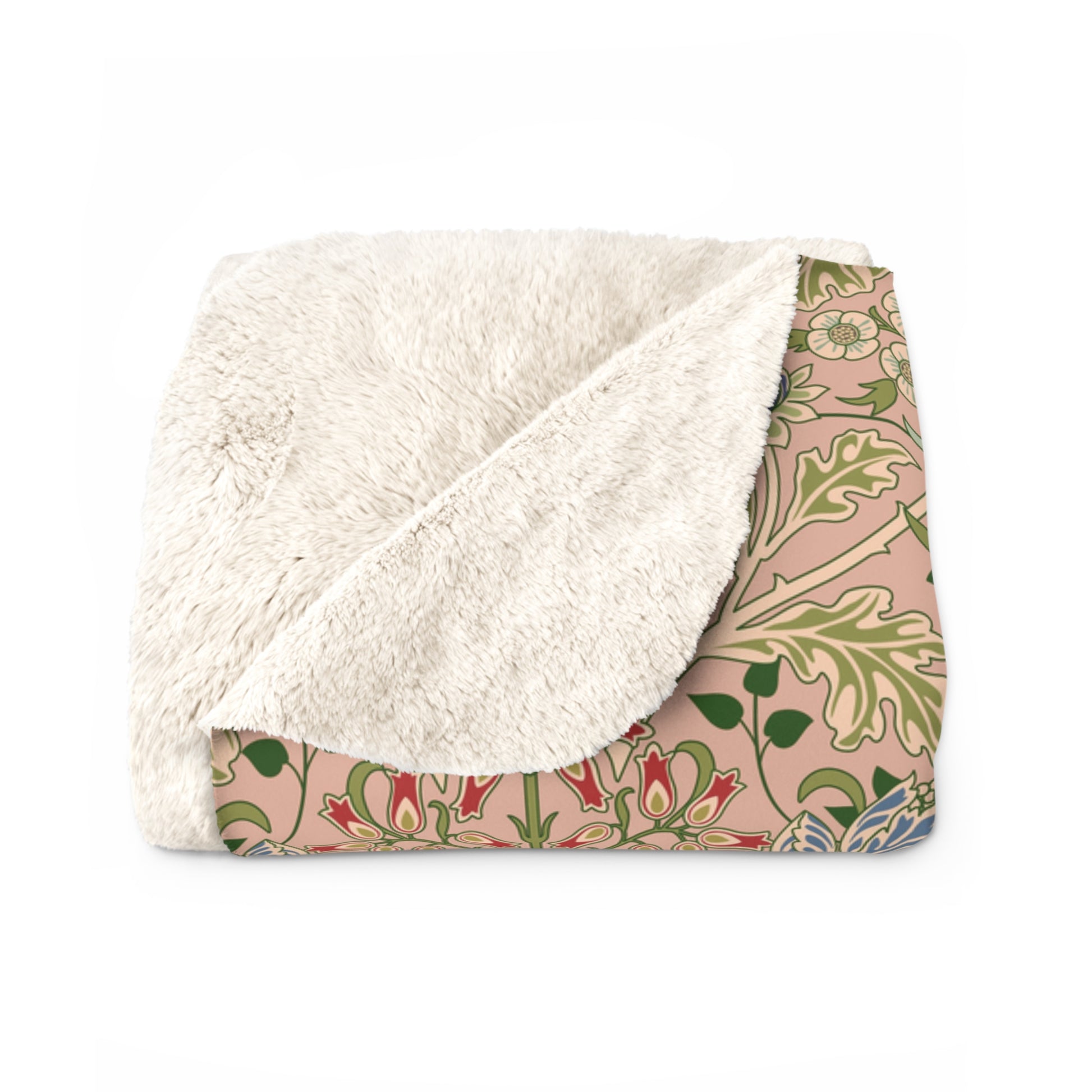 A Sherpa fleece blanket with a floral pattern in pink, green and beige colours on a pink background.