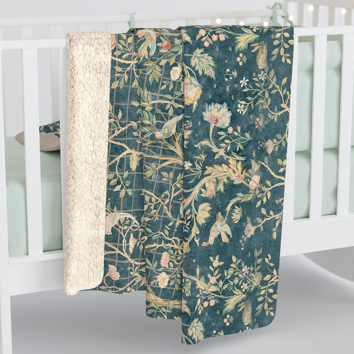 A Sherpa fleece blanket with an all-over floral William Morris & Co pattern in various colours, predominantly teal and cream.