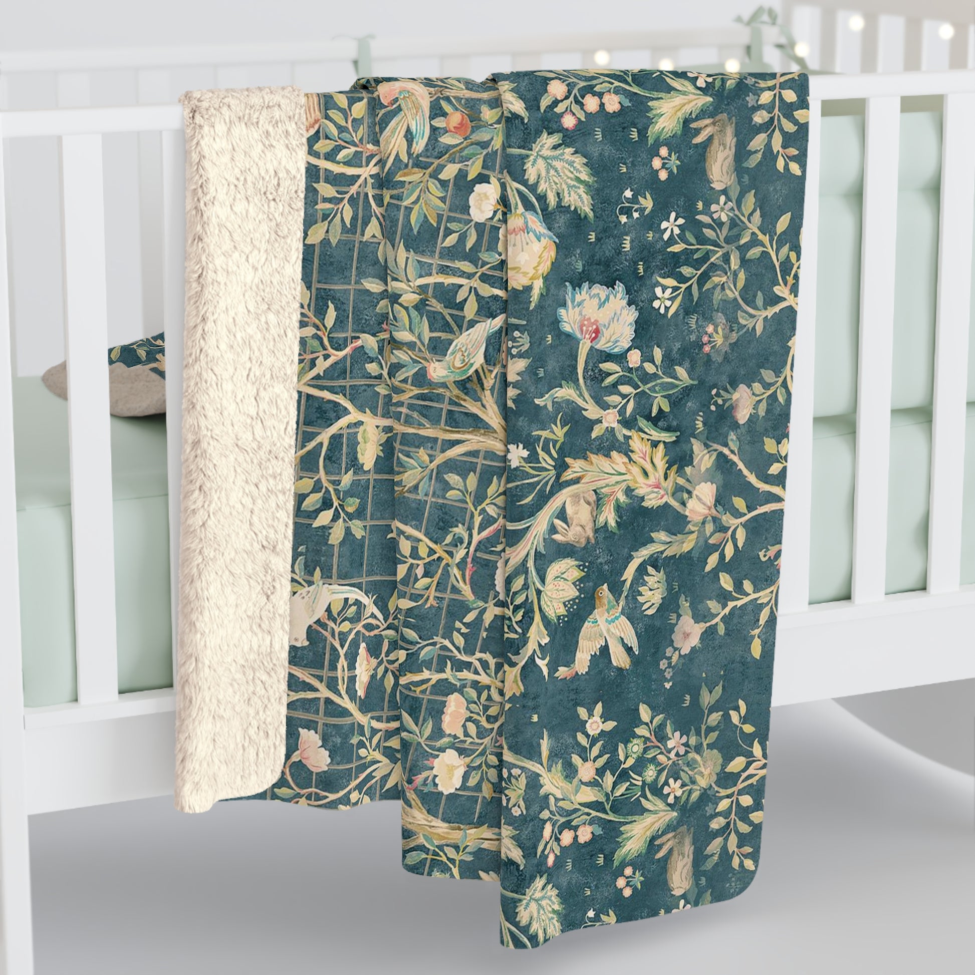 A Sherpa fleece blanket with an all-over floral William Morris & Co pattern in various colours, predominantly teal and cream.