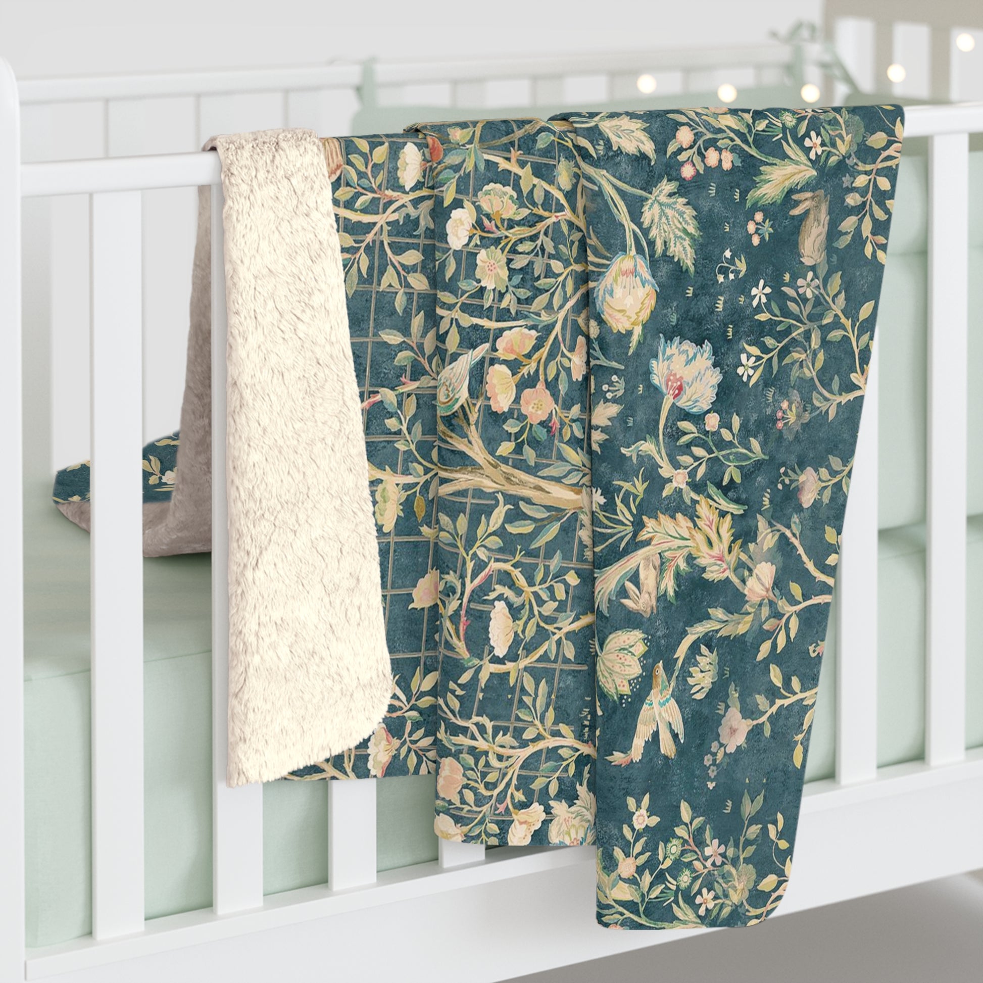A Sherpa fleece blanket with an all-over floral William Morris & Co pattern in various colours, predominantly teal and cream.