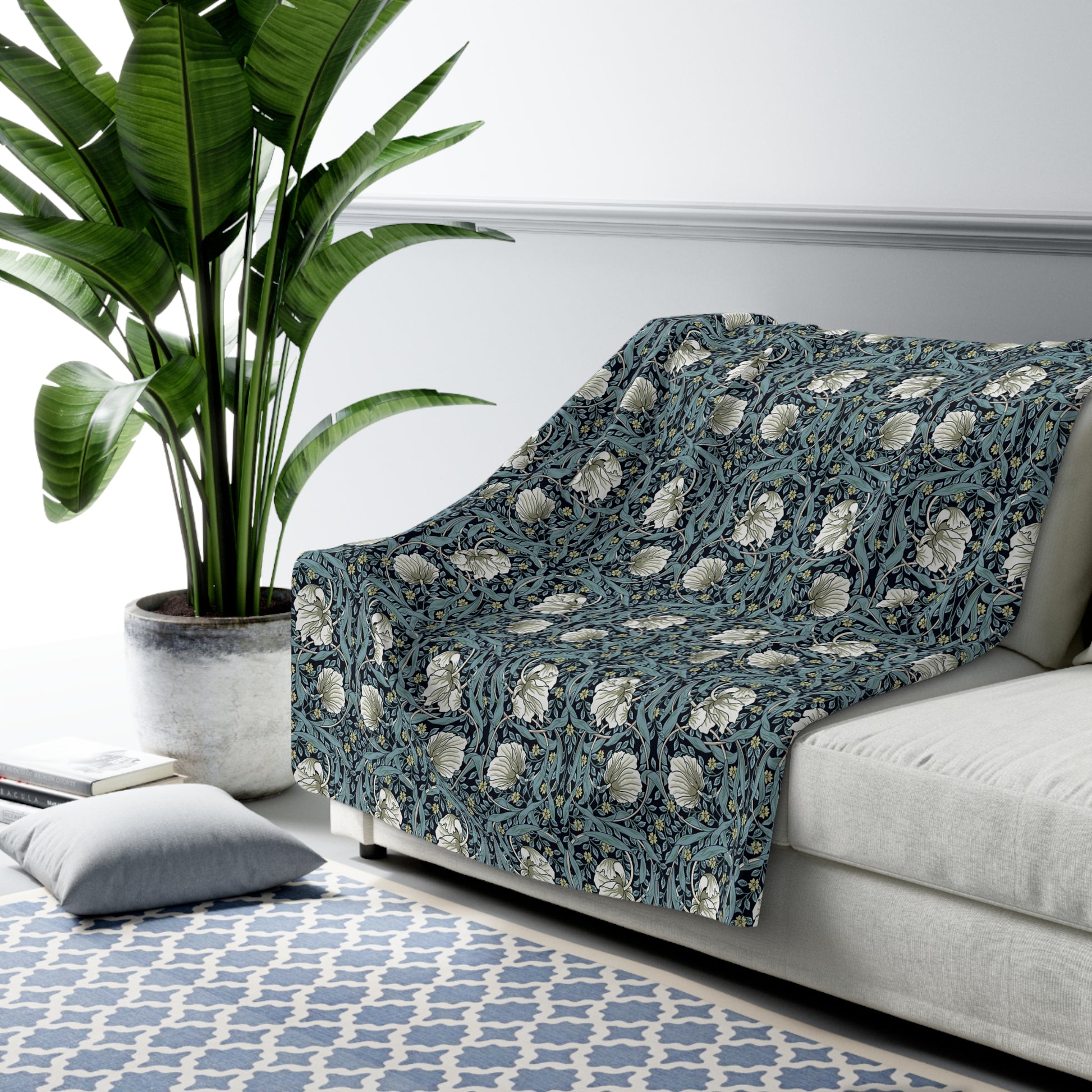 A plush fleece blanket with a geometric William Morris & Co pattern in a slate blue colour, featuring a dense, cozy texture.