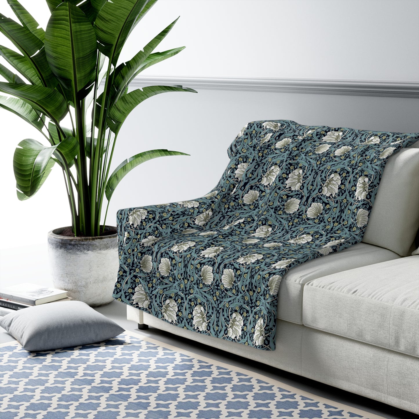 A plush fleece blanket with a geometric William Morris & Co pattern in a slate blue colour, featuring a dense, cozy texture.