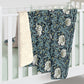 A plush fleece blanket with a geometric William Morris & Co pattern in a slate blue colour, featuring a dense, cozy texture.