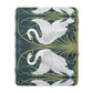 A Sherpa fleece blanket with a floral and swan William Morris & Co pattern in white and green colours on a dark background.