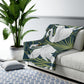 A Sherpa fleece blanket with a floral and swan William Morris & Co pattern in white and green colours on a dark background.