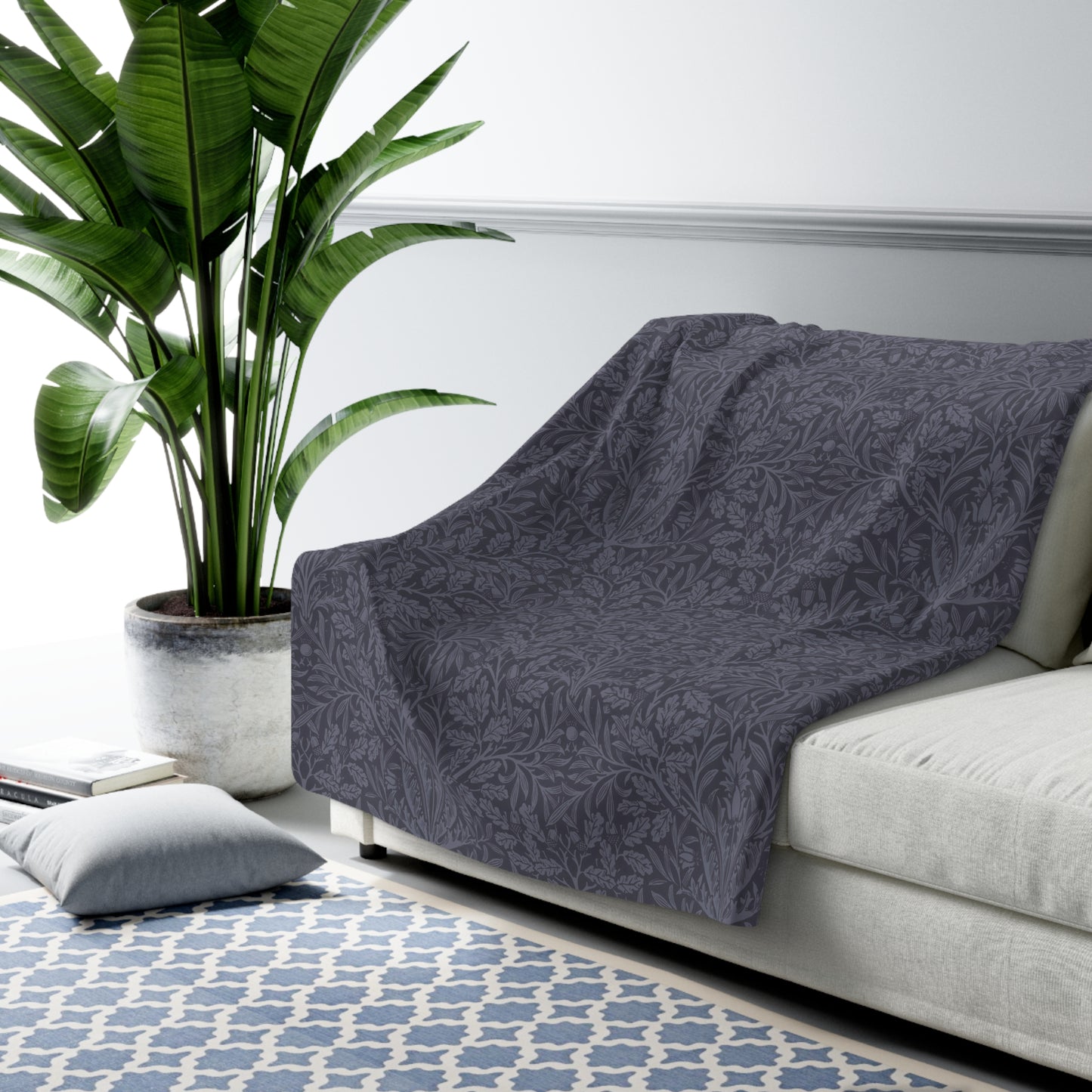 A smoky blue Sherpa fleece blanket with a floral pattern, made inspired by William Morris' Acorn and Oak Leaves collection.