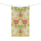 A kitchen tea towel with a floral pattern inspired by William Morris, featuring honeysuckle designs in red, yellow, and green on a light background.