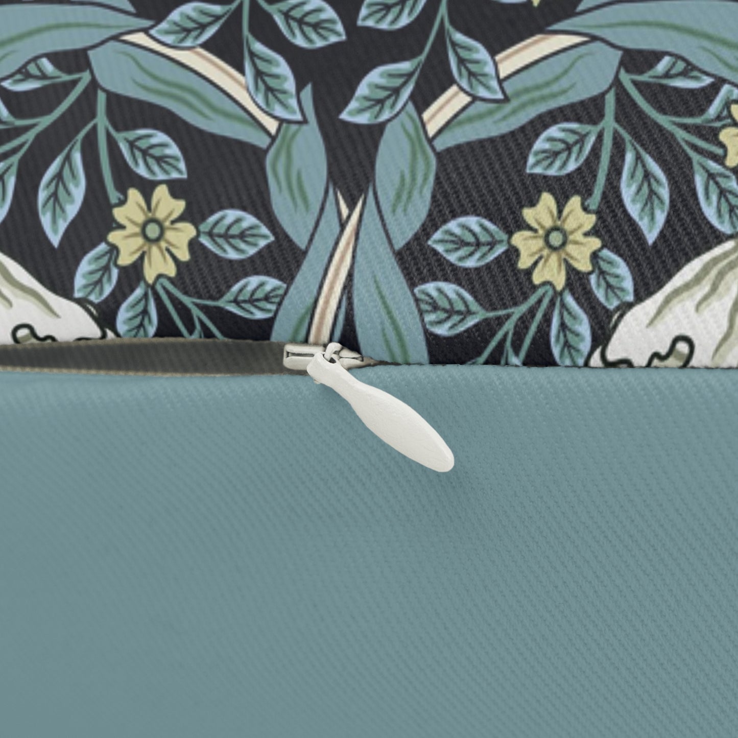 A rectangular lumbar cushion with a William Morris & Co floral pattern in shades of blue, beige, and white, featuring a concealed beige zipper.