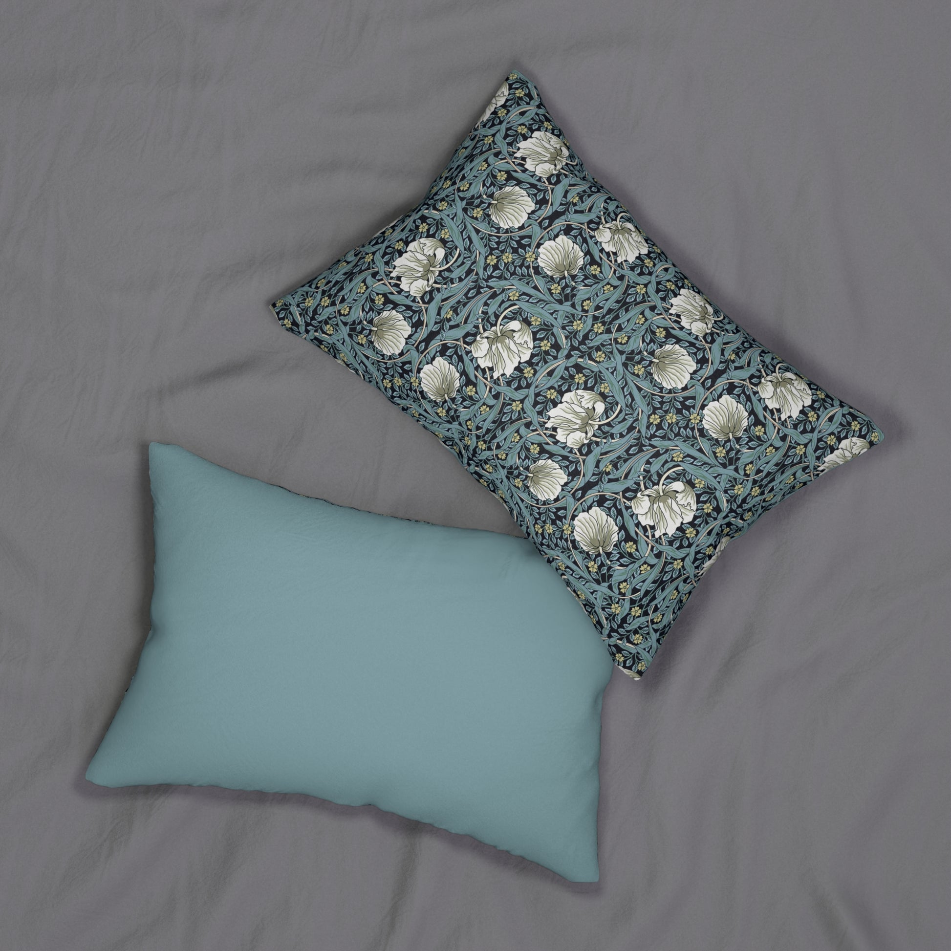 A rectangular lumbar cushion with a William Morris & Co floral pattern in shades of blue, beige, and white, featuring a concealed beige zipper.