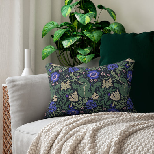 A rectangular lumbar cushion with a floral William Morris & Co pattern featuring predominantly blue flowers and green leaves on a darker background.