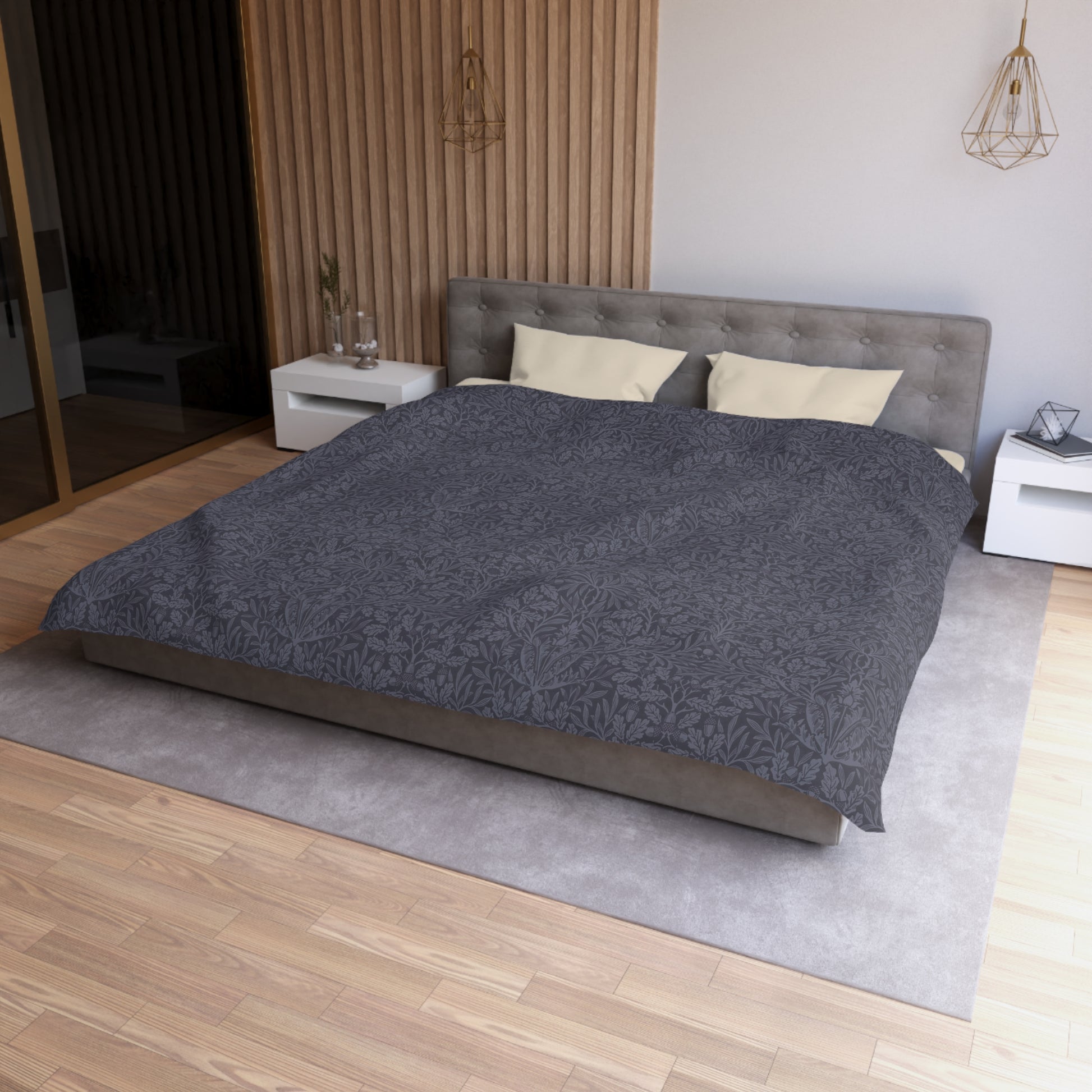 Gray textured comforter on a bed in a bedroom setting with wooden flooring and neutral walls.