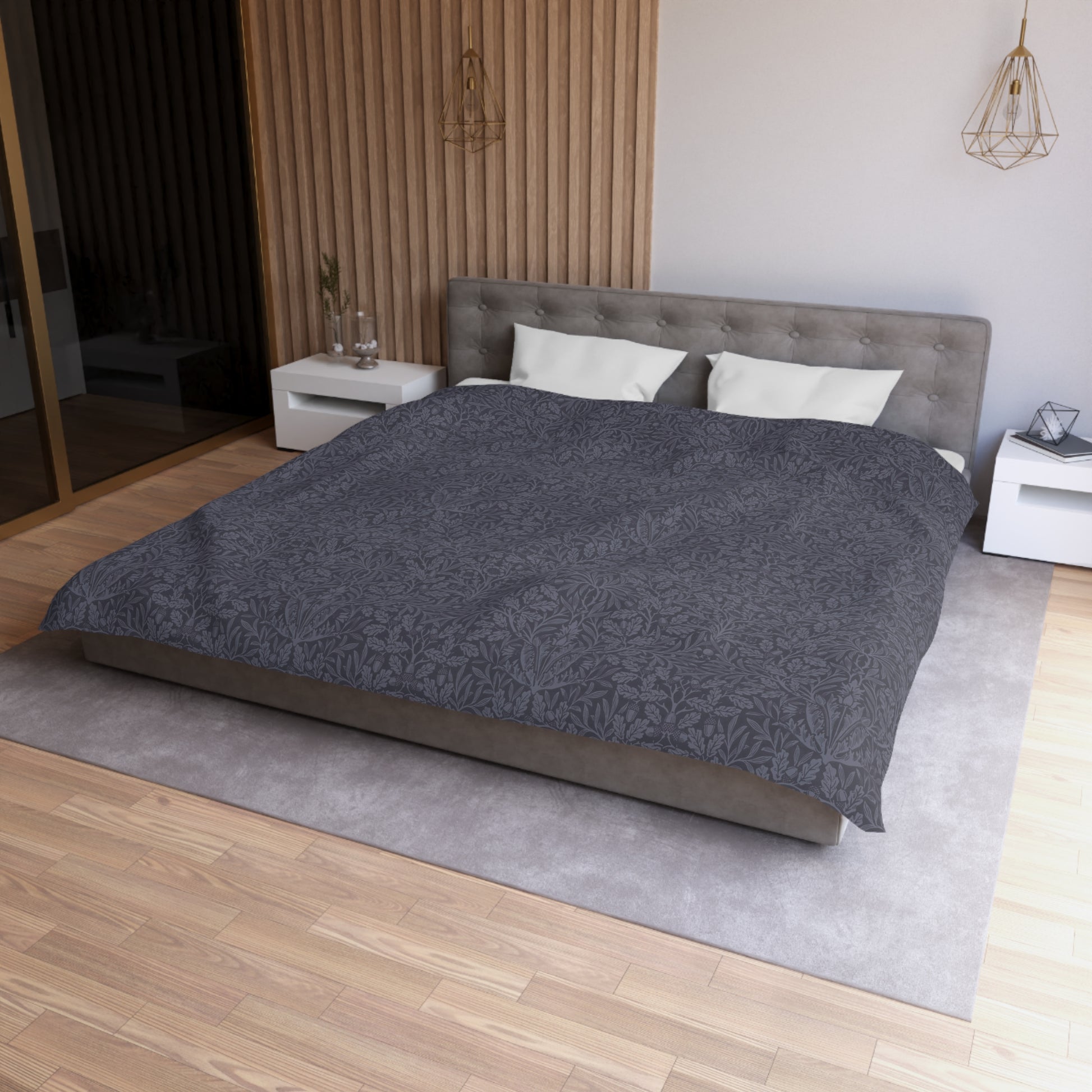Modern bedroom with a gray bedspread on a bed, wooden floor, and neutral walls.