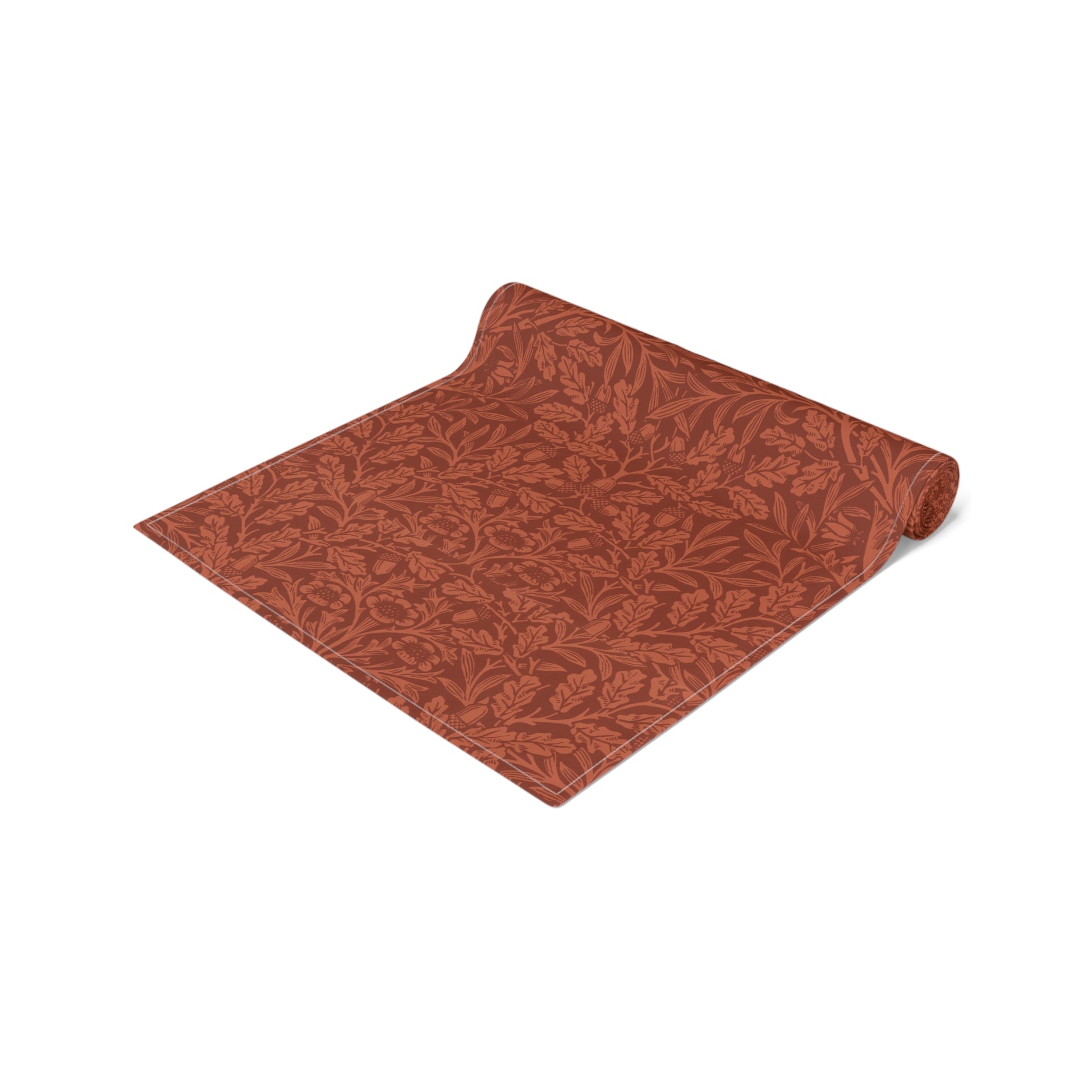 A rust-coloured table runner with a floral William Morris & Co pattern displayed on a dining table.