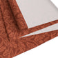 A rust-coloured table runner with a floral William Morris & Co pattern displayed on a dining table.