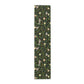 A table runner with a Victorian-inspired bird and pomegranate William Morris & Co pattern in black, green, and white, displayed on a dining table.
