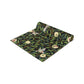 A table runner with a Victorian-inspired bird and pomegranate William Morris & Co pattern in black, green, and white, displayed on a dining table.