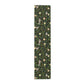 A table runner with a Victorian-inspired bird and pomegranate William Morris & Co pattern in black, green, and white, displayed on a dining table.