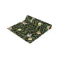 A table runner with a Victorian-inspired bird and pomegranate William Morris & Co pattern in black, green, and white, displayed on a dining table.