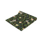 A table runner with a Victorian-inspired bird and pomegranate William Morris & Co pattern in black, green, and white, displayed on a dining table.