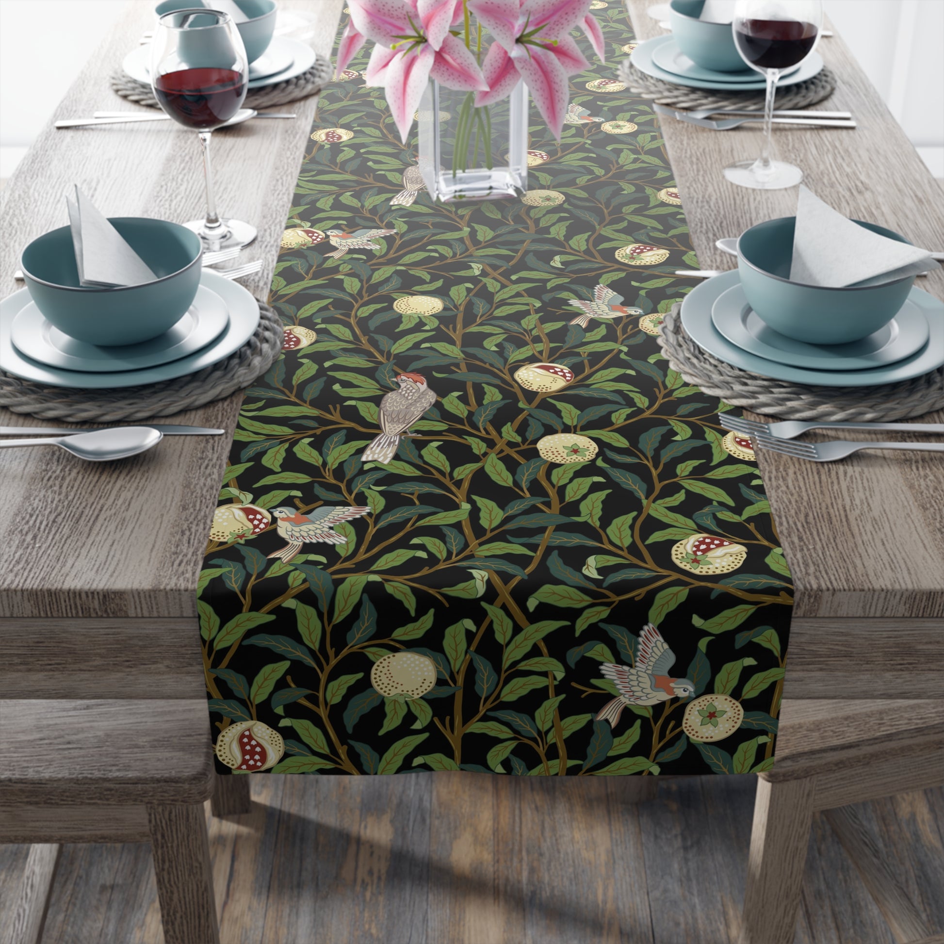 A table runner with a Victorian-inspired bird and pomegranate pattern in black, green, and white, displayed on a dining table.