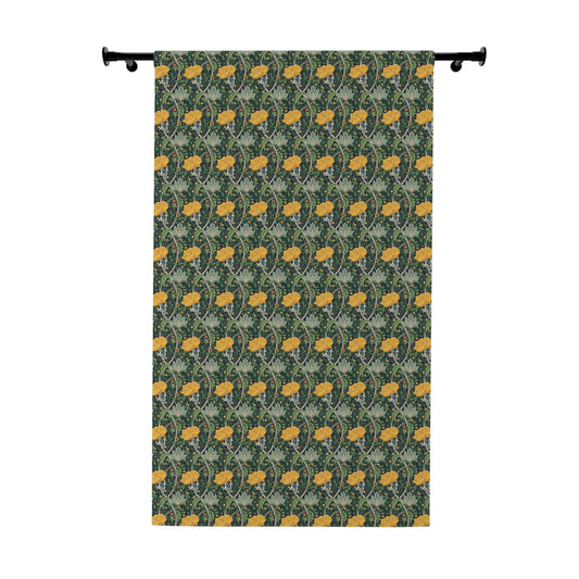 Decorative fabric with yellow floral pattern on a green background, hanging on a rod.