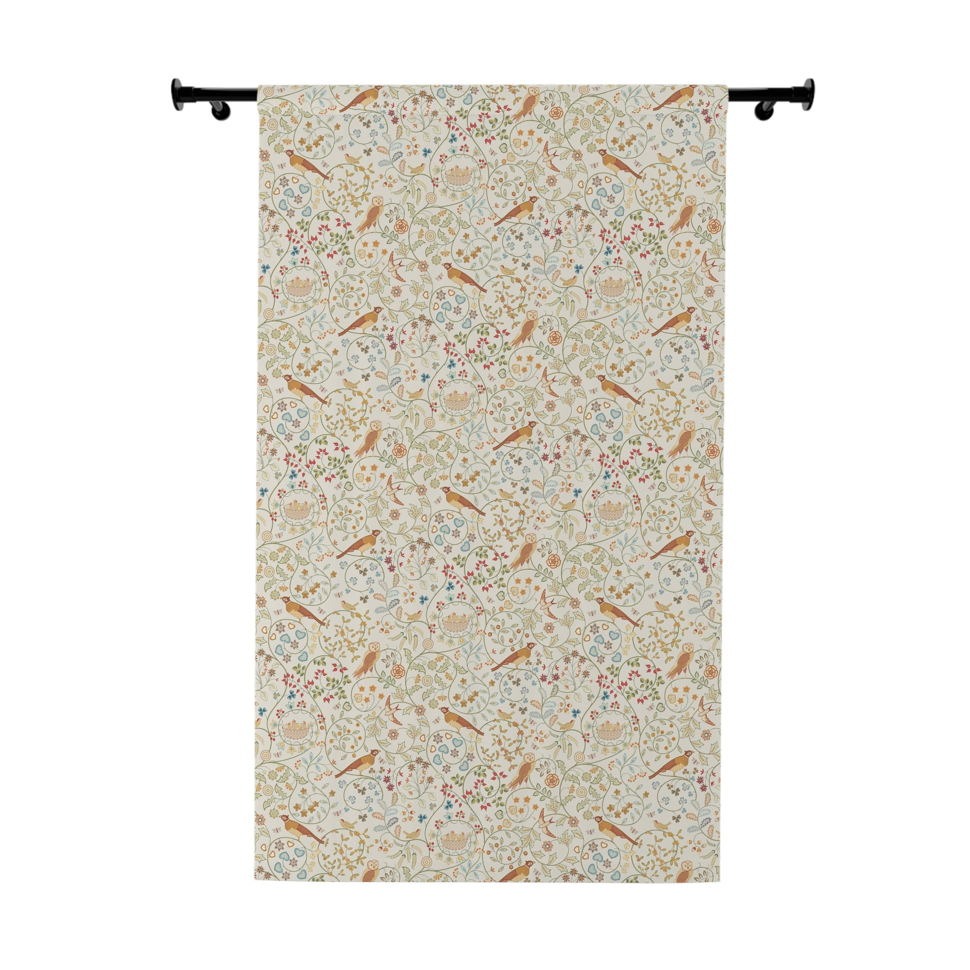 Floral and bird patterned fabric hanging on a rod against a white background