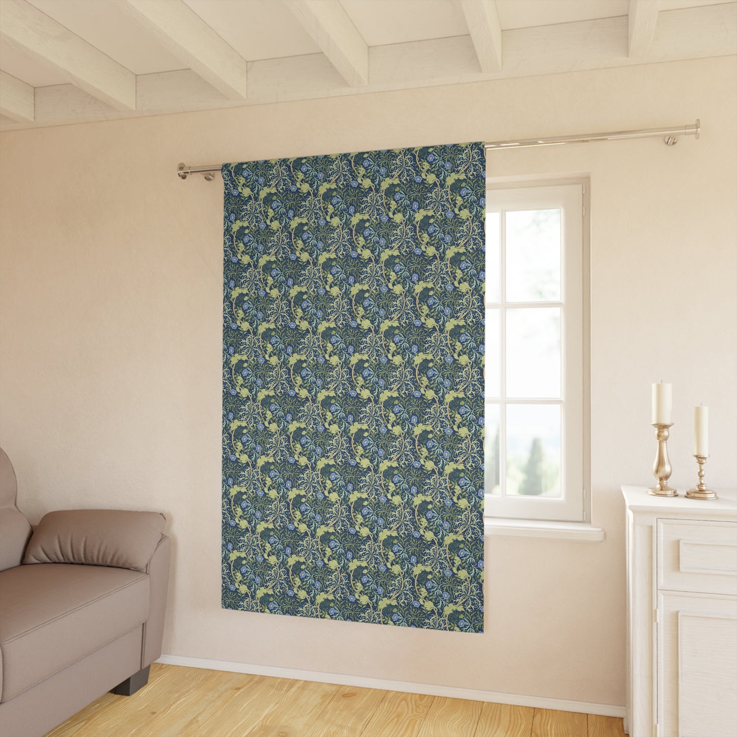 Patterned blue curtain hanging in a room with a sofa and window.