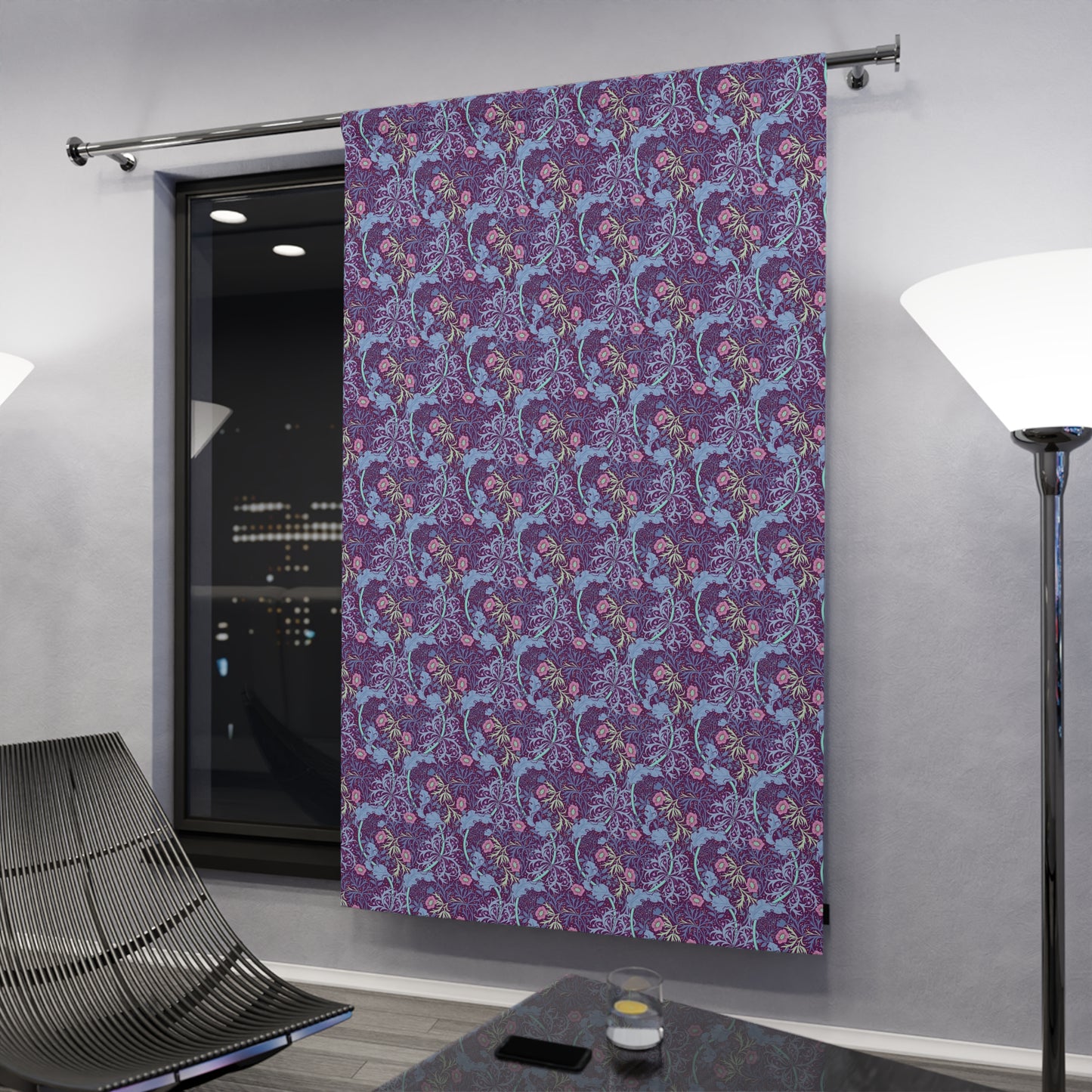 Decorative purple curtain with floral pattern hanging in a room.