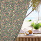 Decorative curtain with floral pattern in front of a beach view