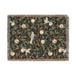 A woven cotton blanket with a geometric pattern featuring birds and pomegranates in a onyx black color, with fringed edges.