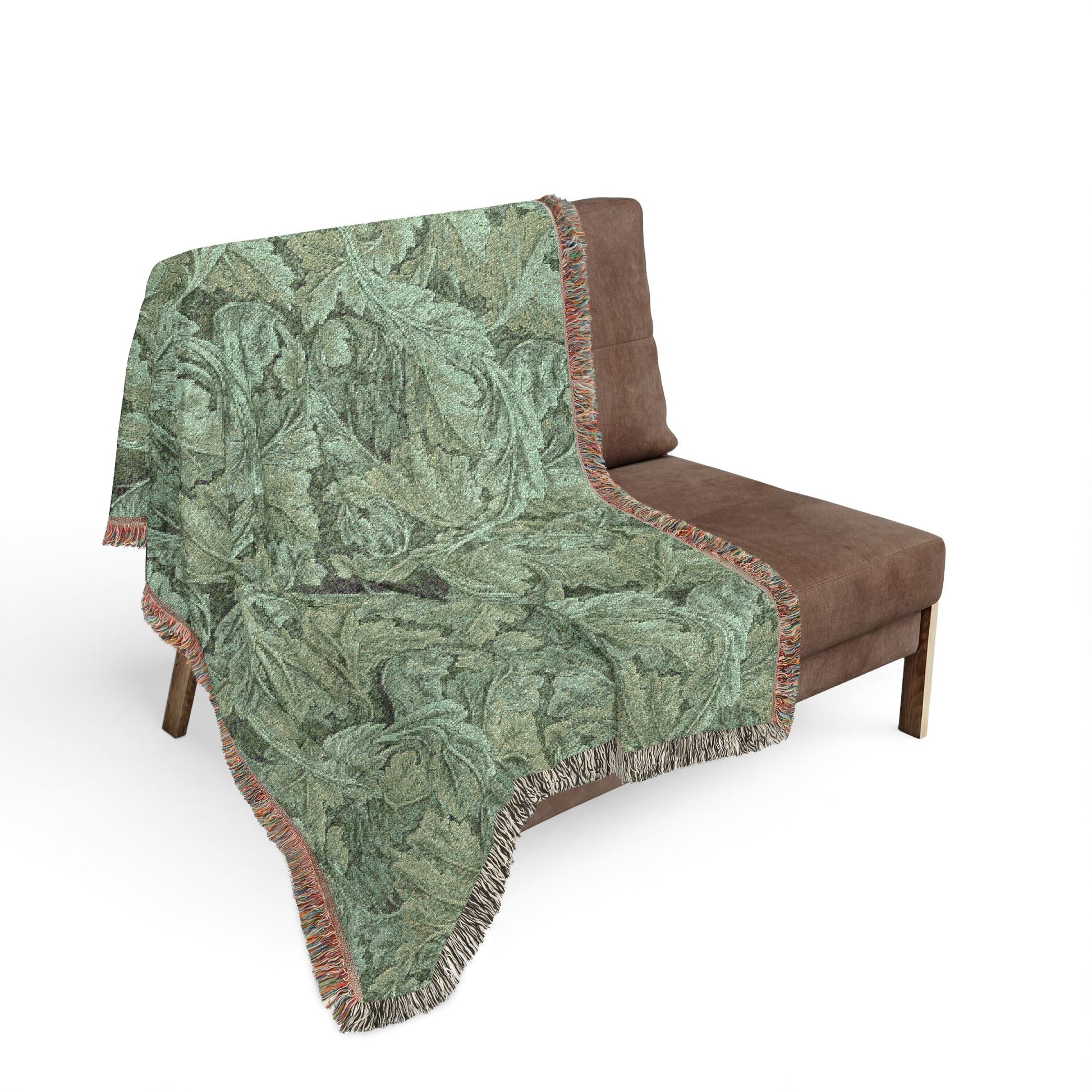 Green patterned throw blanket draped over a brown chair on a white background