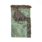 Decorative throw blanket with floral pattern and fringed edges on a white background