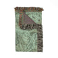 Green patterned throw blanket with fringed edges on a white background
