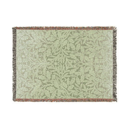 Green woven blanket with leaf pattern on a white background