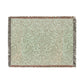 A green woven blanket with a floral pattern and colorful fringed edges displayed on a plain background.