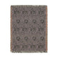 A rectangular woven throw blanket with fringed edges, featuring a muted purple and gray floral pattern with a warm brown border, shown flat against a white background.