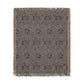 A rectangular woven throw blanket with a textured, heathered pattern in shades of gray, purple, and black, featuring a subtle repeating medallion design and fringed edges.