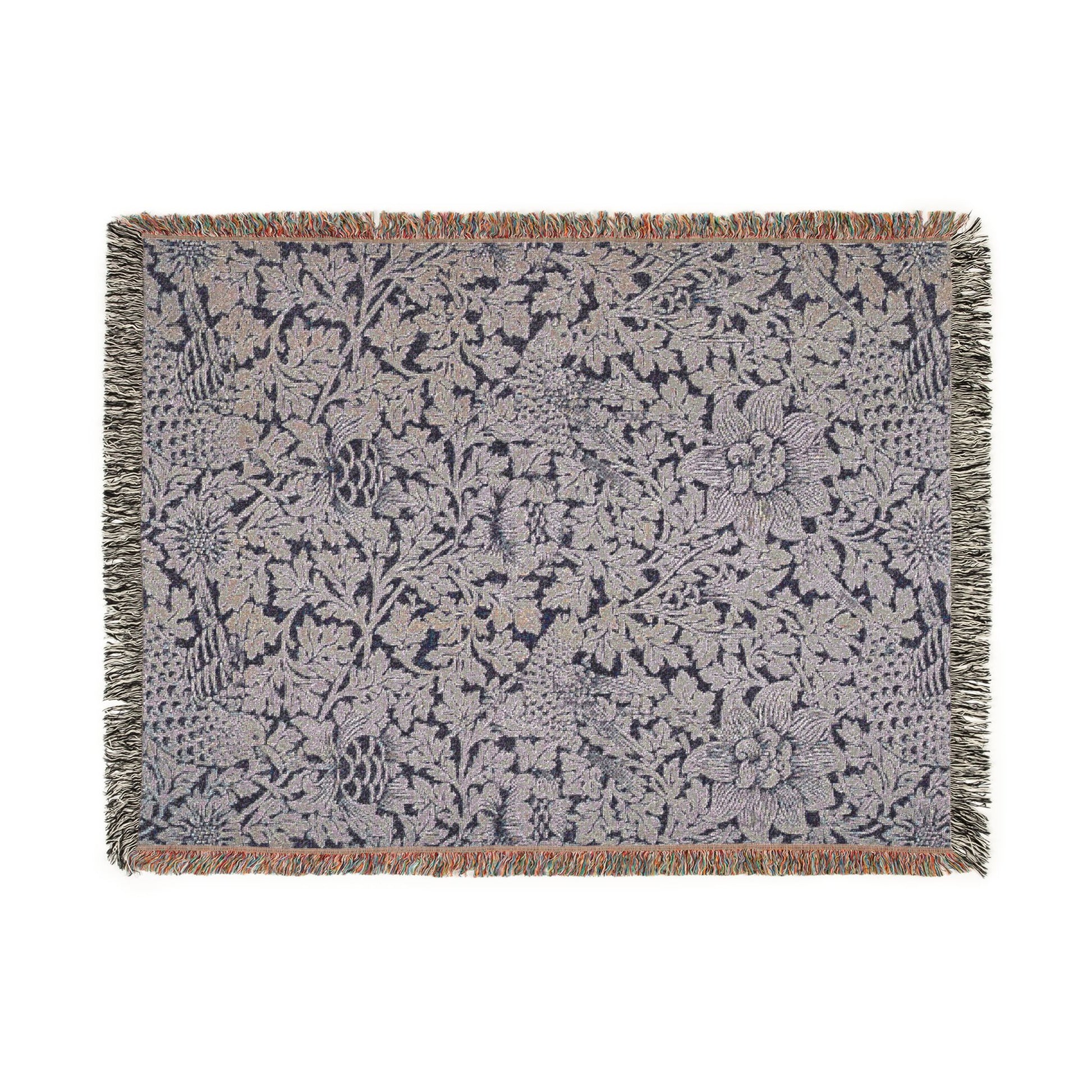 Floral patterned throw blanket with fringe on a white background