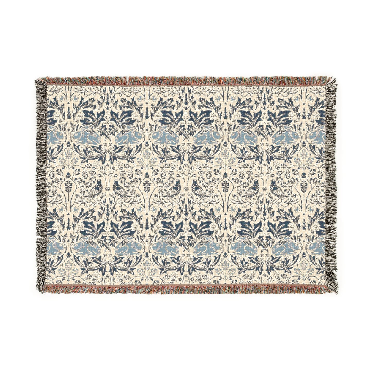 A woven cotton blanket with a geometric William Morris & Co pattern in gray, blue, and beige colours, featuring fringed edges.