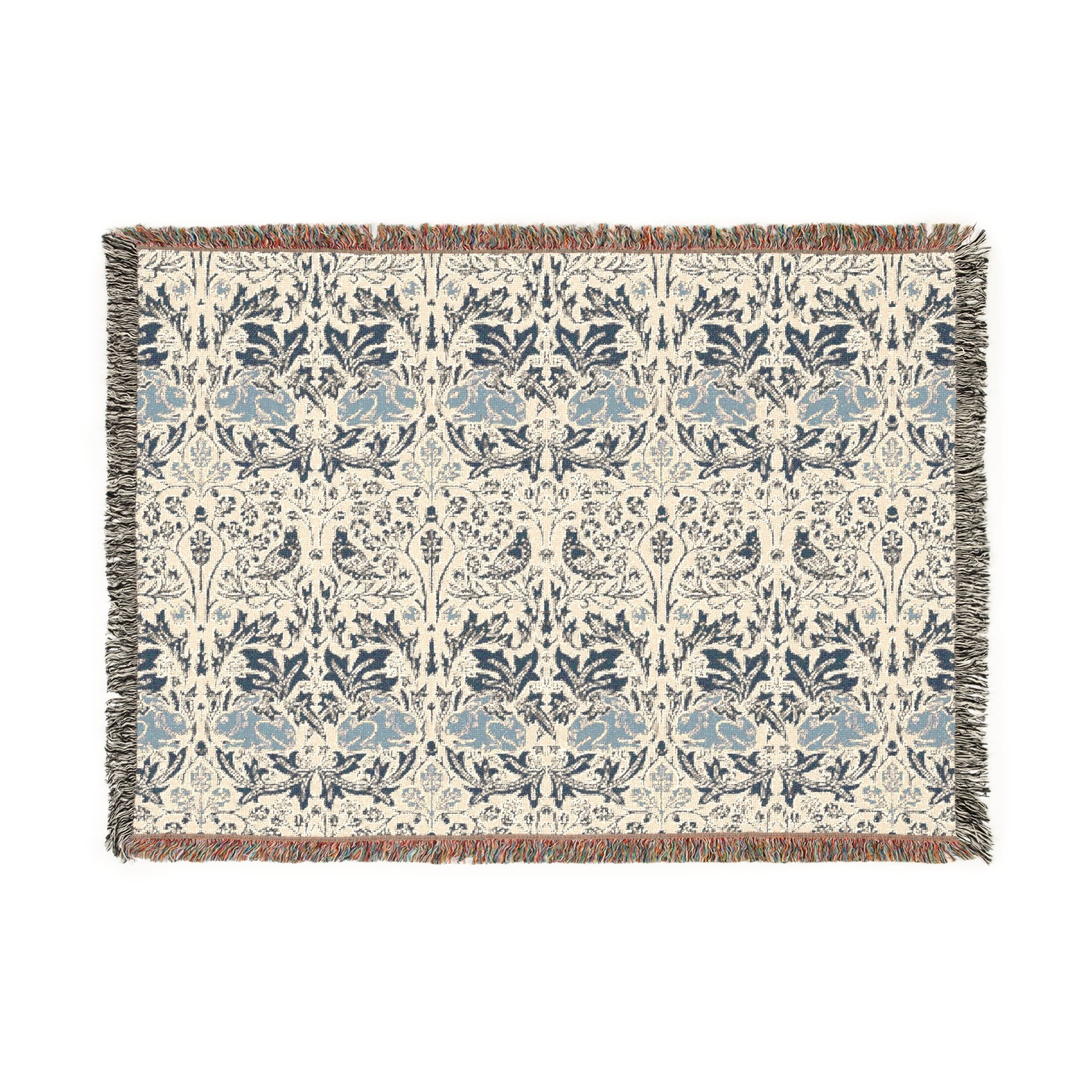 A woven cotton blanket with a geometric William Morris & Co pattern in gray, blue, and beige colours, featuring fringed edges.