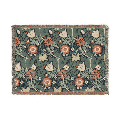 A woven cotton blanket with a William Morris & Co floral pattern in green, brown, and beige colours, featuring colourful fringed edges.