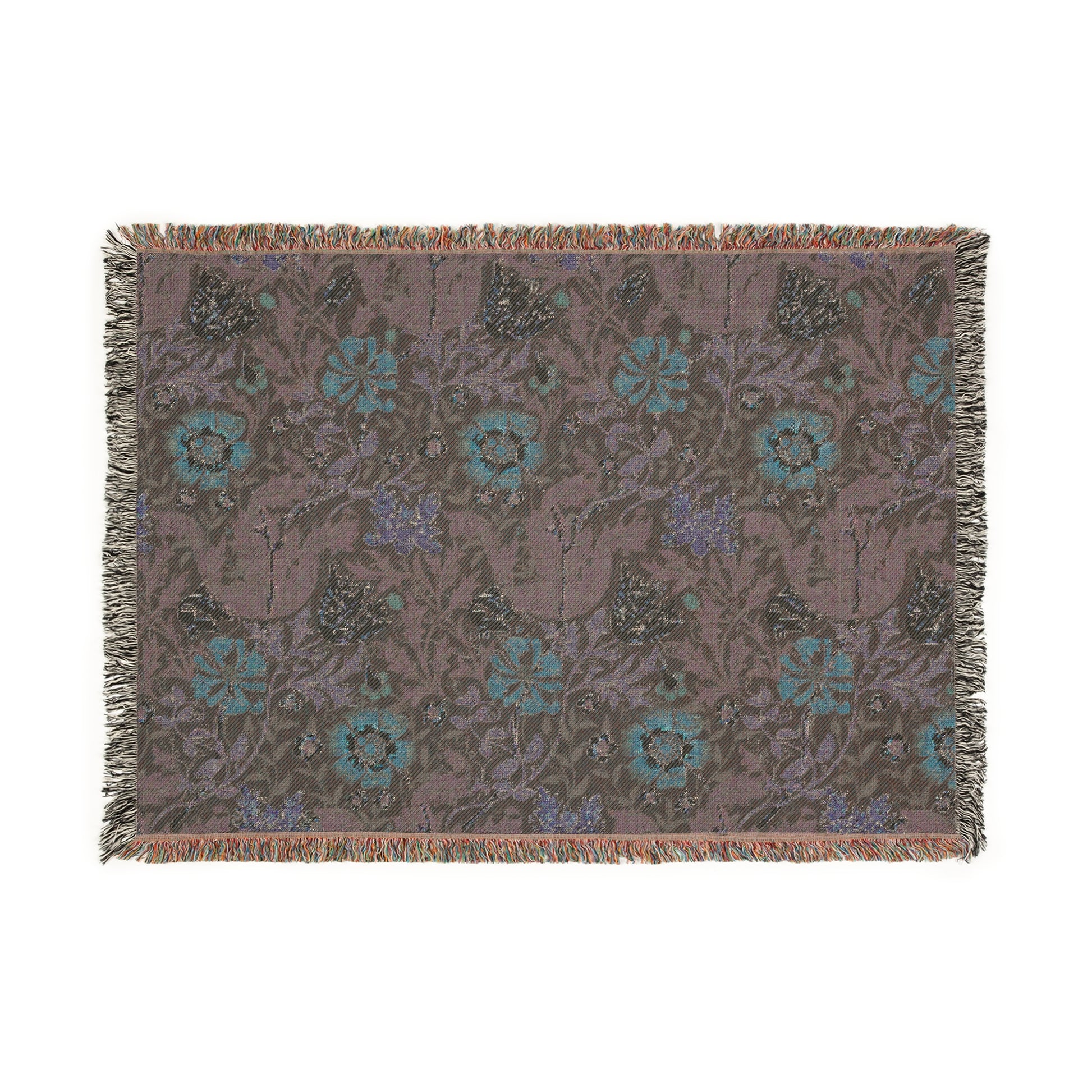 A woven cotton blanket with a William Morris & Co floral pattern in green, brown, and beige colours, featuring colourful fringed edges.