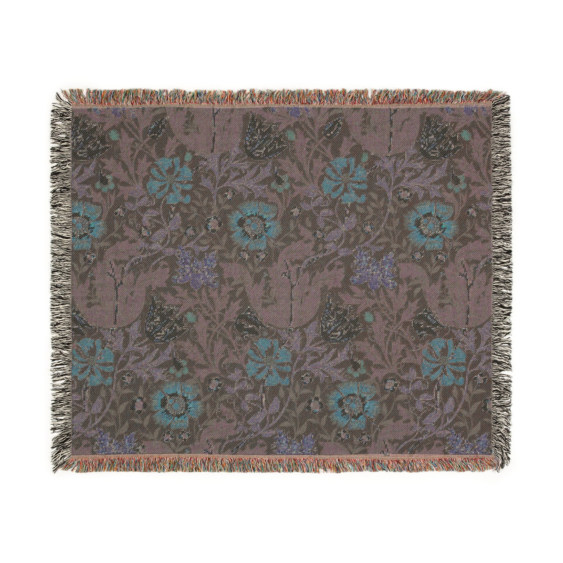 A woven cotton blanket with a William Morris & Co floral pattern in green, brown, and beige colours, featuring colourful fringed edges.