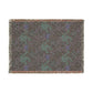 Woven blanket with a pattern of deer and flowers on a plain background
