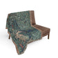 Decorative blanket with nature-themed design draped over a brown chair on a white background