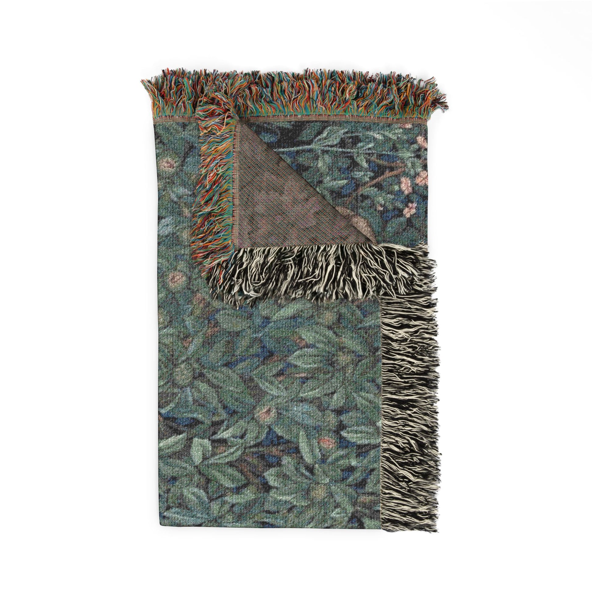 Woven blanket with leaf pattern and fringed edges on a white background