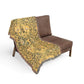 Brown chair with a yellow patterned throw blanket on a white background