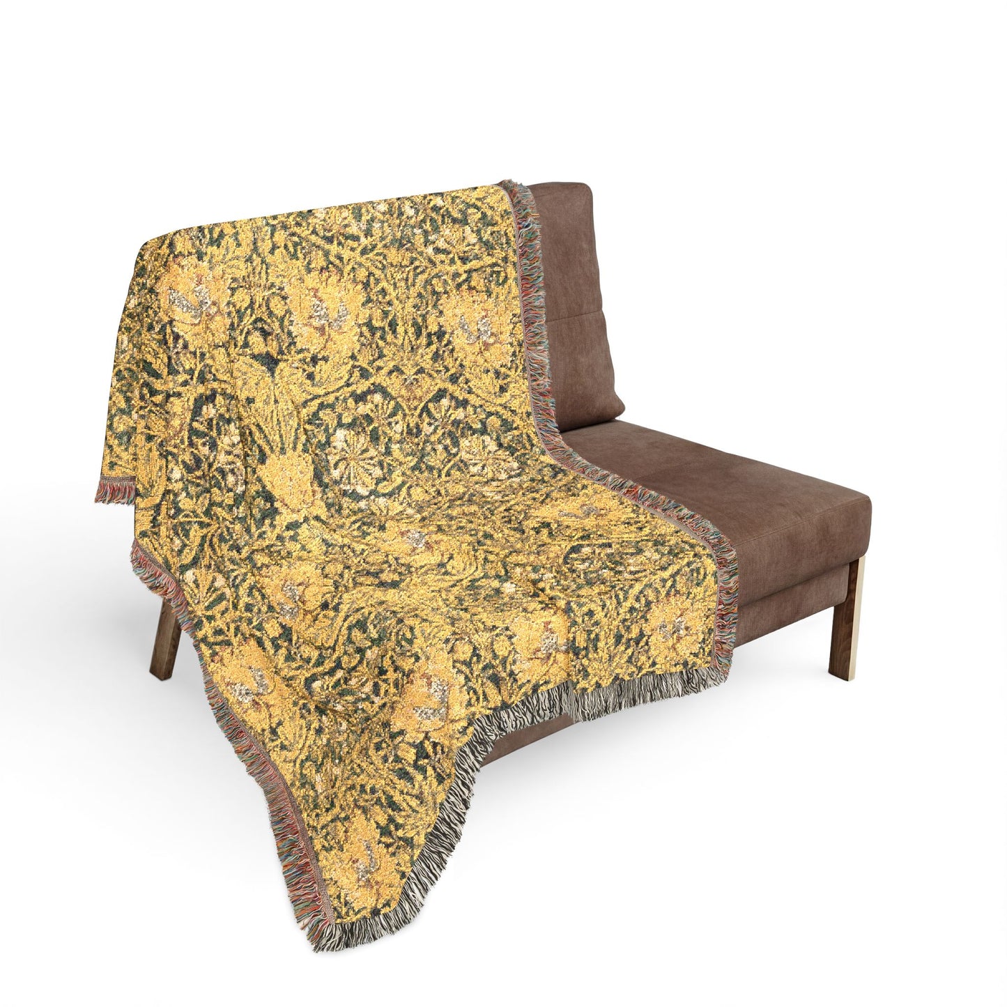 Decorative yellow patterned throw blanket on a brown sofa against a white background