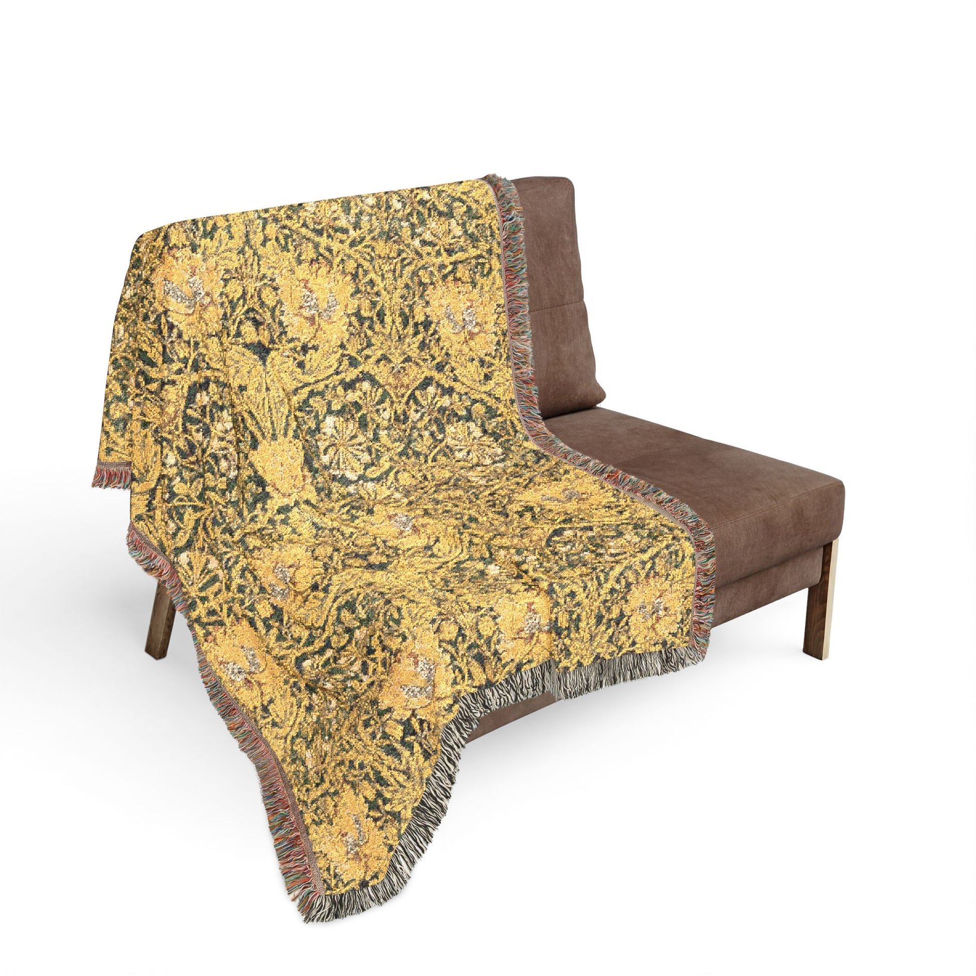 Decorative yellow patterned throw blanket on a brown sofa against a white background